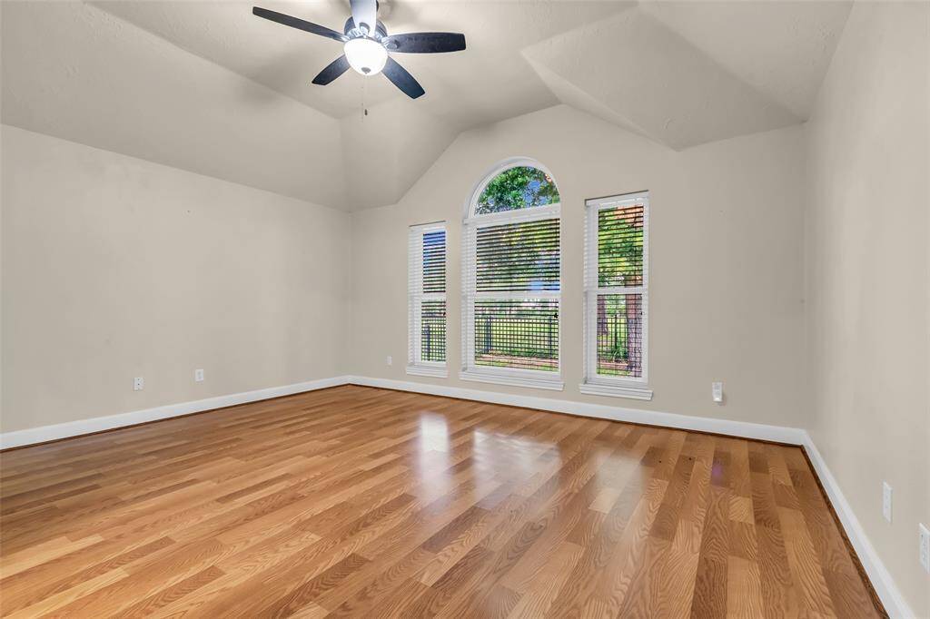 Private primary suite with cathedral ceilings and views towards back yard and golf course beyond.