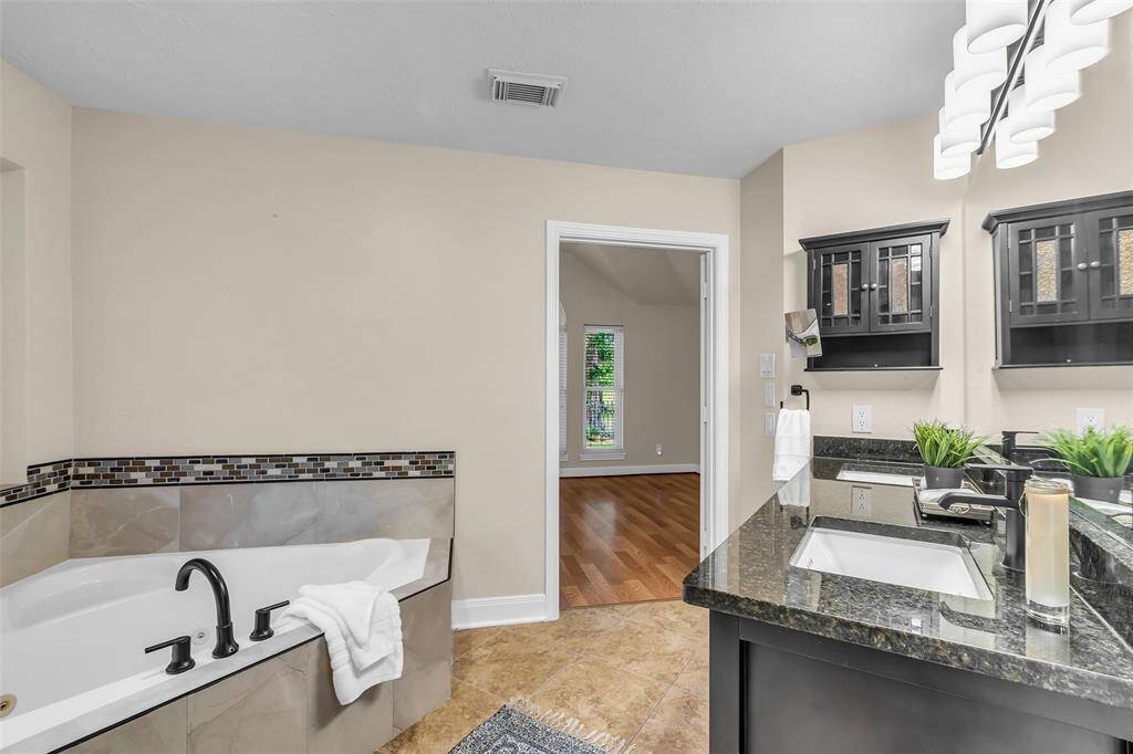Relax in the large corner jetted tub after a long day.  View from primary bath towards bedroom.