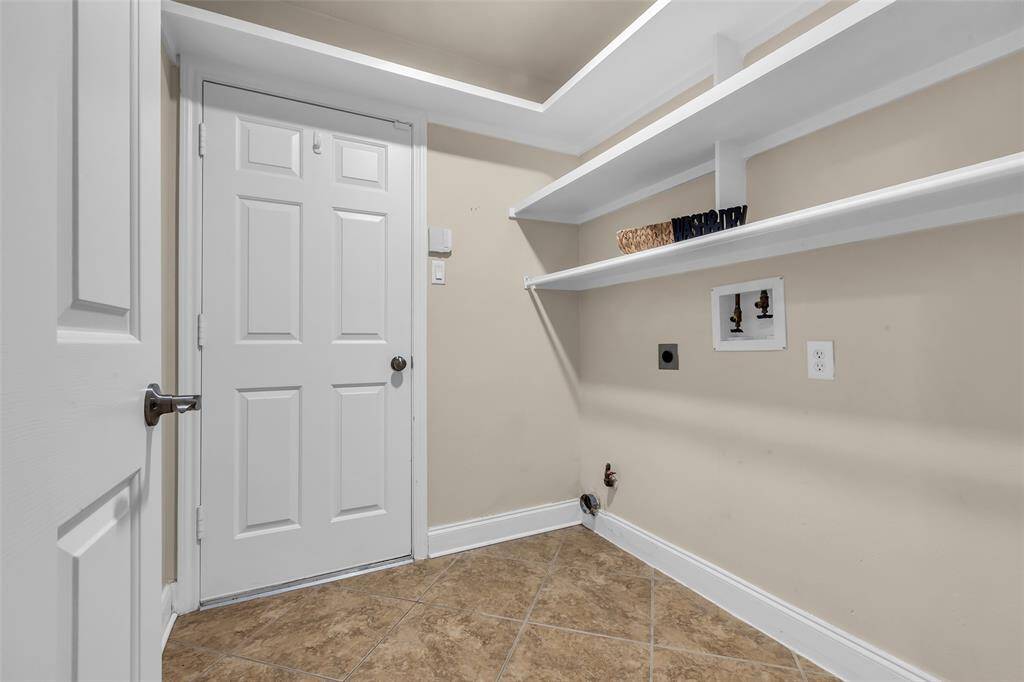 Separate laundry room has lots of storage space and opens to garage.