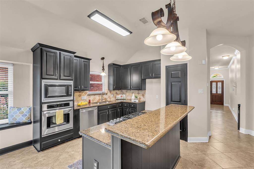 Large center island with breakfast bar and six burner gas cooktop let's you enjoy preparing means while visiting with family and guests.