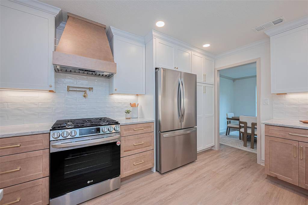 FULLY remodeled kitchen will delight your inner chef.  Features ALL NEW sleek stainless-steel appliances, designer range hood, custom soft closed cabinetry and elegant quartzite counters, The open layout flows into a dining area, with lovely window over the sink providing plenty of natural light. Tons of storage in the built-in pantry. Perfect for cooking and entertaining.