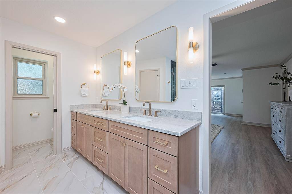 Beautiful Primary Bathroom with pretty tiled floors, custom cabinetry, quartz countertops, double sinks, large mirrors, recessed and wall lighting with dimmer switches.
