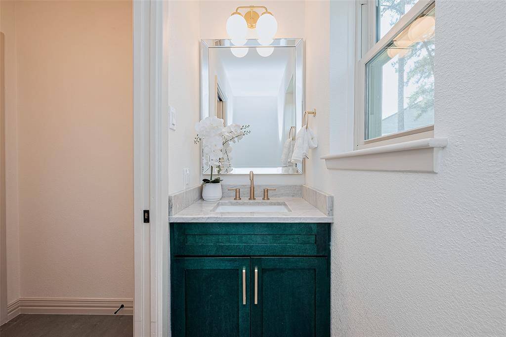 If a 1/2 bath could be called lovely, this one surely is. The custom cabinetry finish, mirror and fixtures blend seamlessly with the rest of this home. Brand new windows throughout home makes for quiet ease of living for years to come.