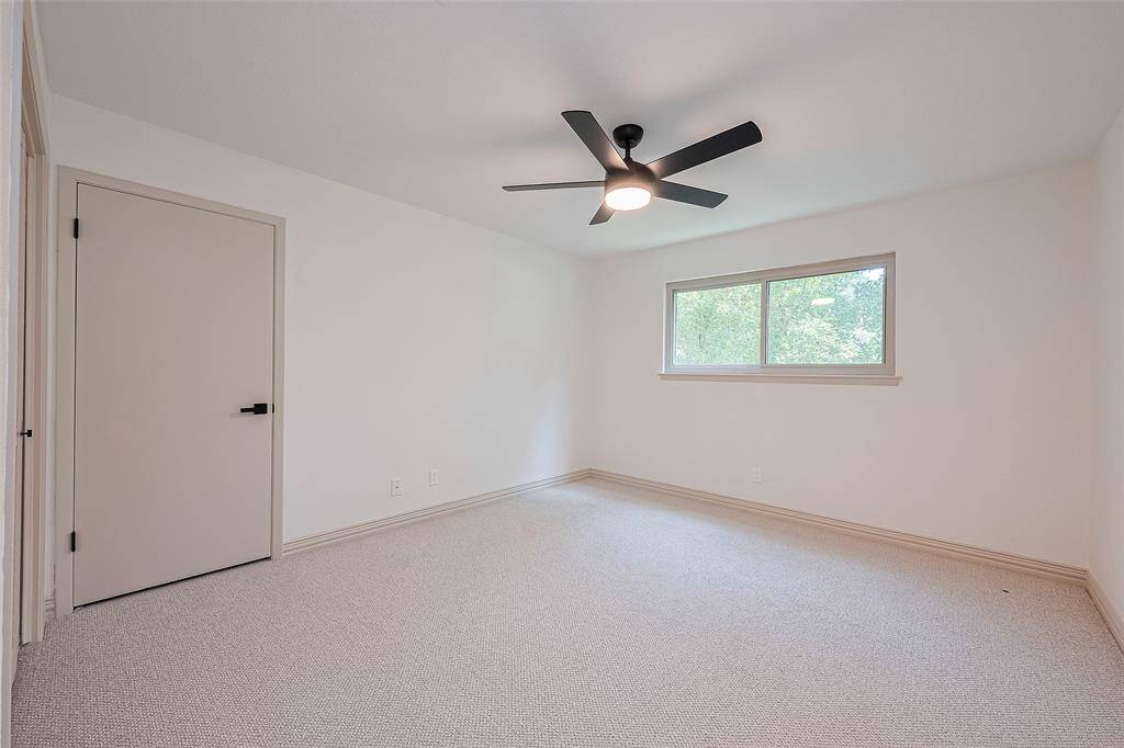 Upstairs 1st of 3 bedrooms, brand new soft neutral carpet and walls, ceiling fan, and a closet with shelving.