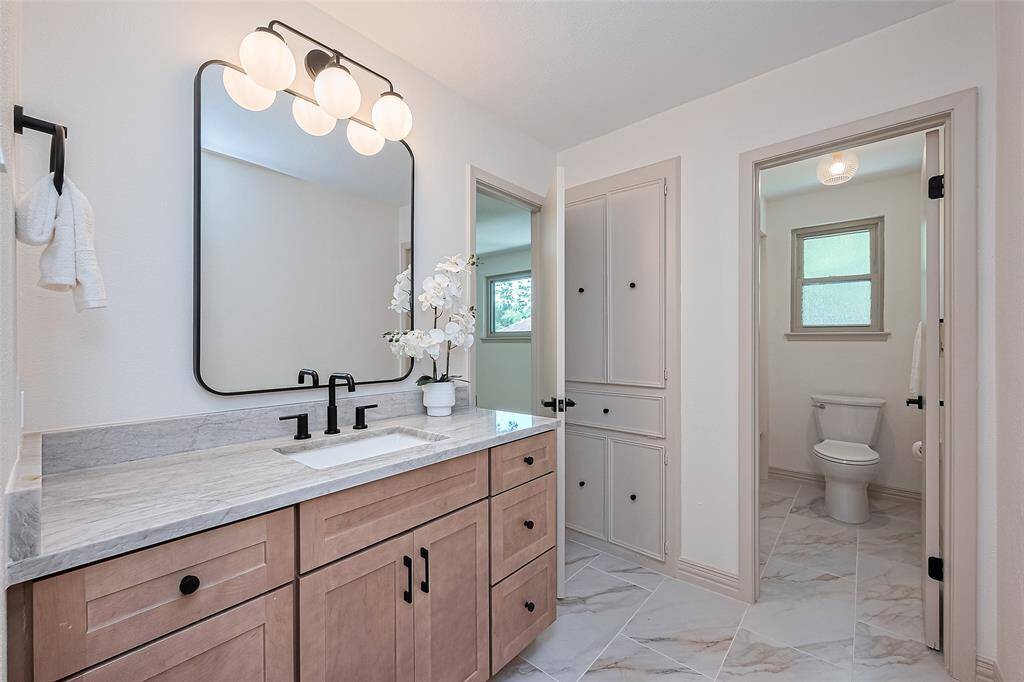How pretty is this full bath. Custom soft close cabinetry and well-appointed modern hardware, counters, mirror, tile floors, and separate water closet - tub/shower with window for fresh air and natural light.