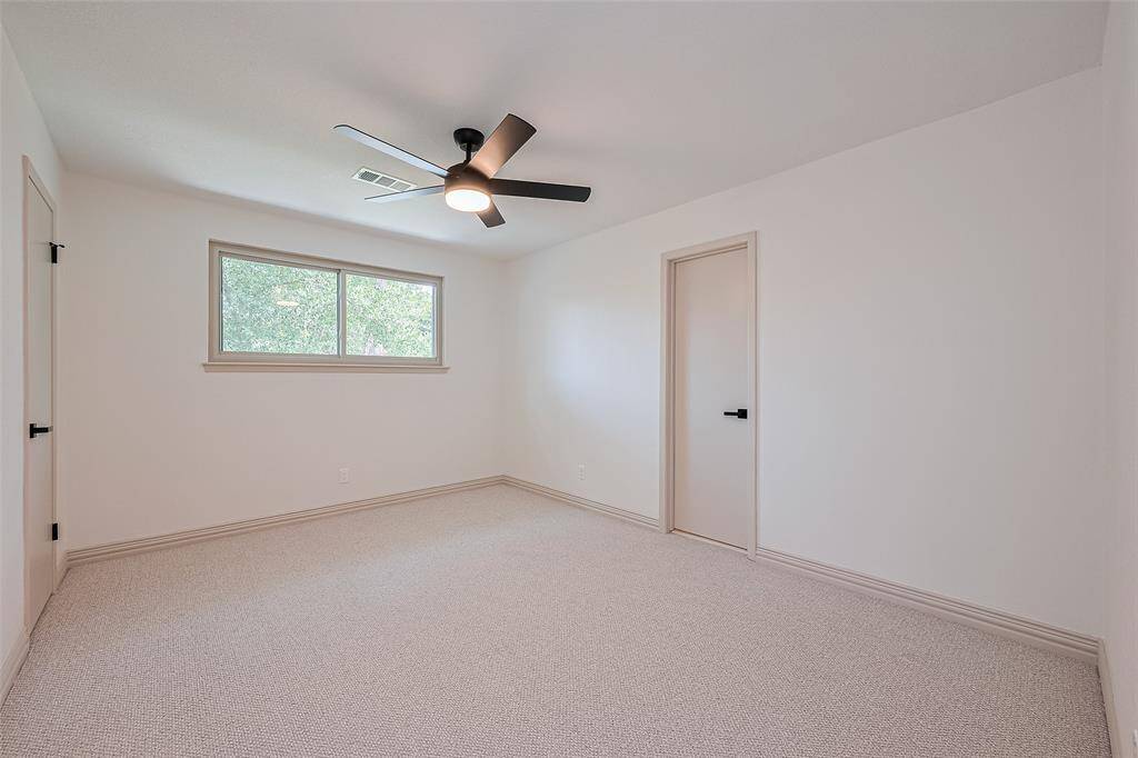 Current design trends, neutral walls, a large window allowing natural light, and a modern ceiling fan. Soft carpeted flooring and a simple, clean design offer a versatile space to use for any purpose.