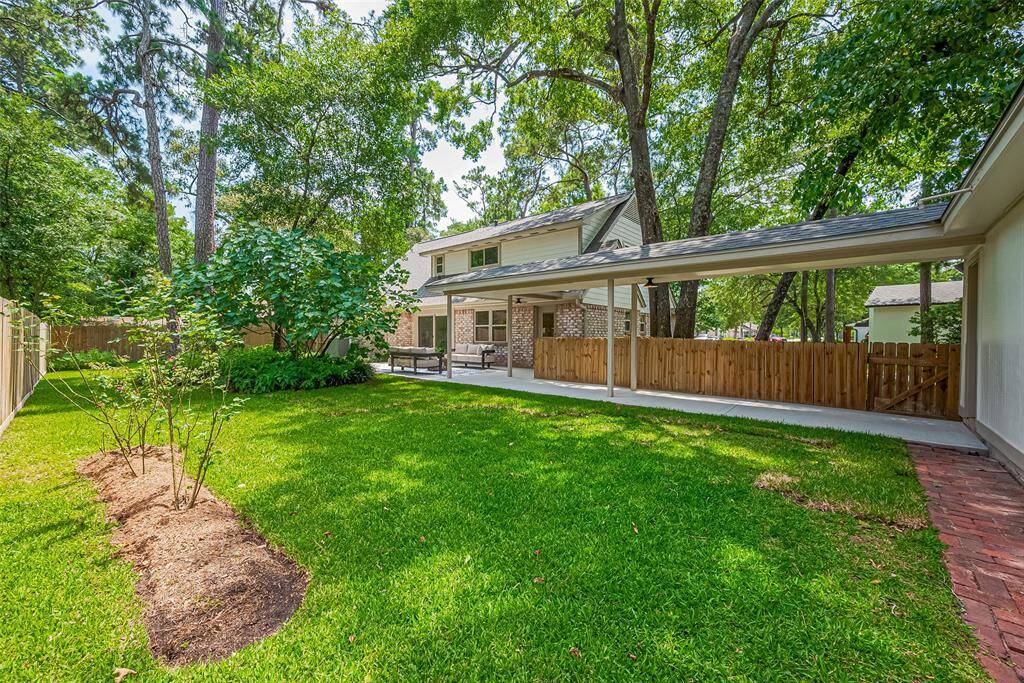 Get ready to enjoy the outdoors! Backyard covered wide walkway from the 2-car detached garage that has a work bench and a workshop, storage, or green house area. Meticulously maintained landscaping, mature trees, the area is perfect for outdoor relaxation and entertainment. A wooden fence provides privacy, enhancing the serene atmosphere.