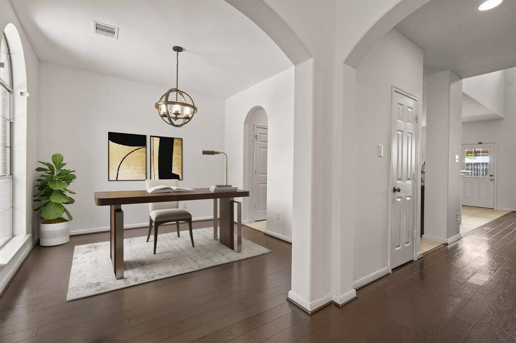 Need extra space? The bonus space offers versatility as a home office, formal dining room, or library — tailored to your needs. It's completed with a modern chandelier, bright natural light, wood floors, and direct access to the kitchen. *This photo has been virtually staged.
