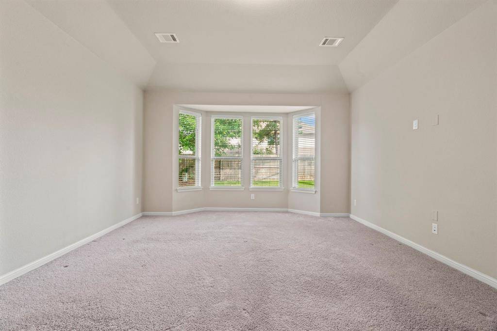 Enjoy abundant natural light and serene views through the elegant bay window in the primary bedroom.