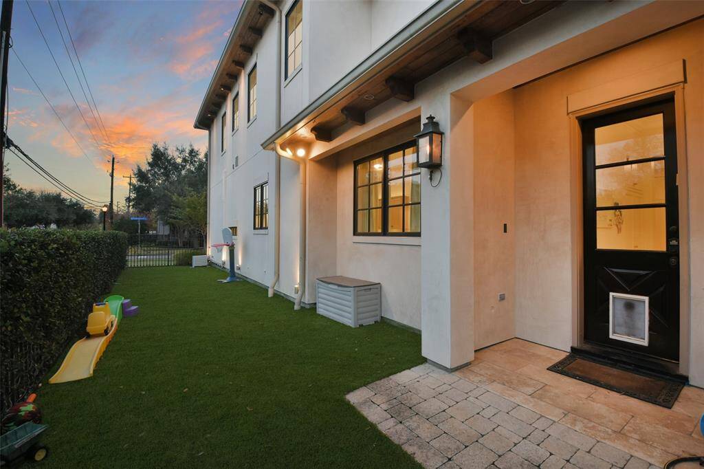 Lined with neatly trimmed hedges, this side yard provides a sense of privacy and tranquility. This charming area is ideal for creating a serene escape, a play area for children or pets, or a functional utility space for storage or gardening tools.
