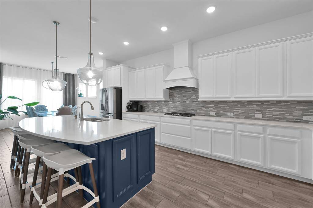 Modern kitchen with stylish backsplash, plenty of cabinets and stainless steel appliances