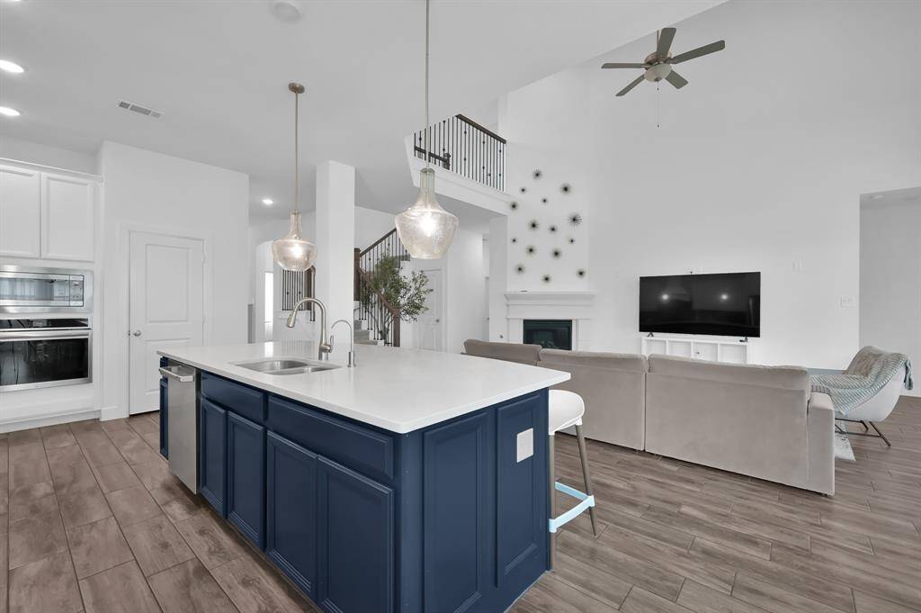 Open-concept floor plan features soaring 20-foot ceilings in the living room, creating a bright and airy space perfect for both everyday living and entertaining.