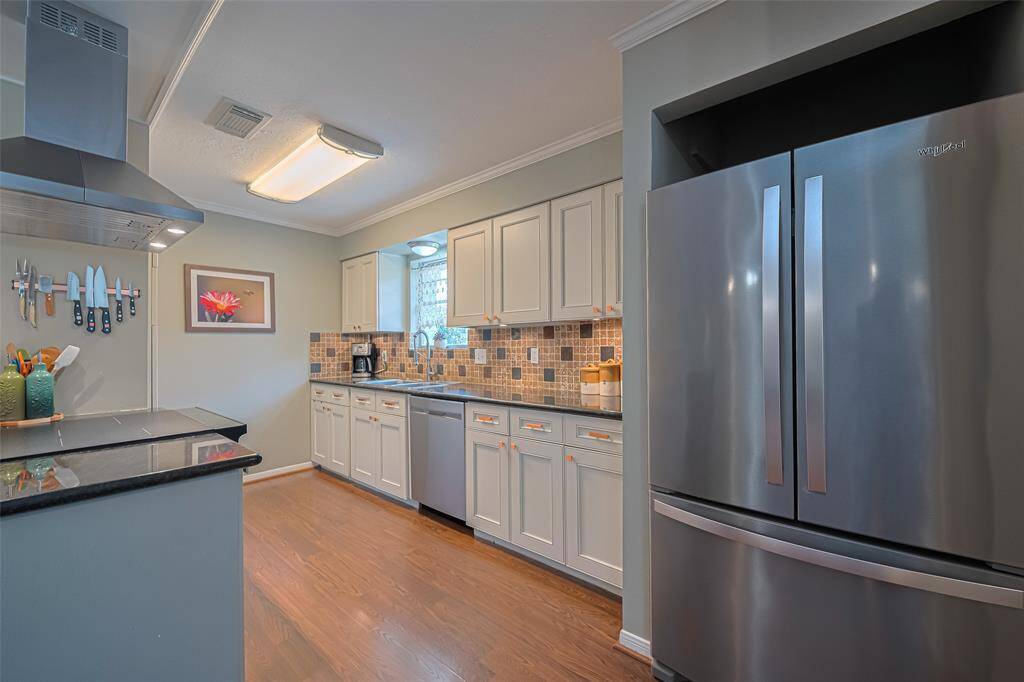 Kitchen is functional with stainless steel appliances and a pantry
