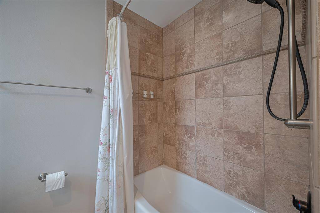 Primary tub shower combination with terracotta color tiles to the ceiling. Updated fixtures compliment the look
