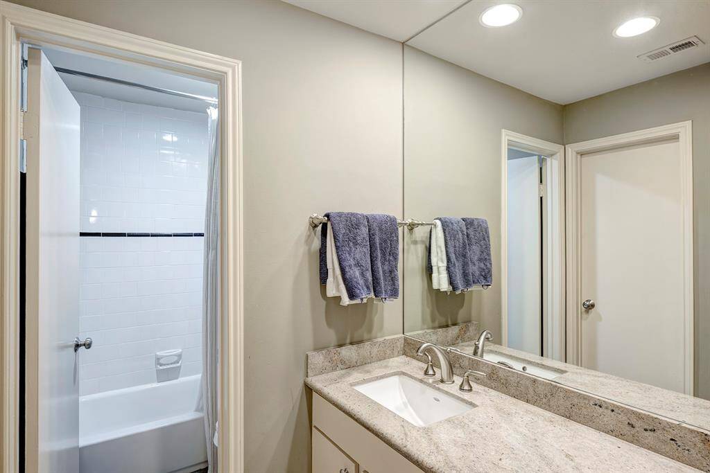 Secondary bathroom with a tub/shower combo, and modern countertop, sink, and fixtures.