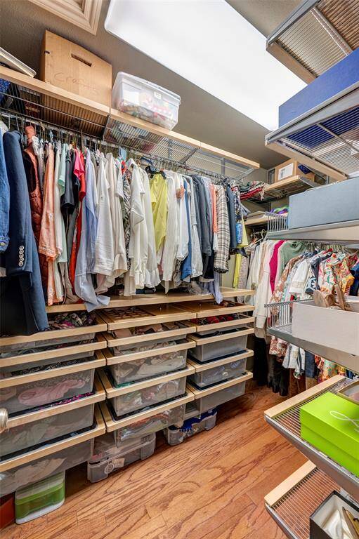 Large primary closet equipped with Elfa shelving for organized storage and maximum space.