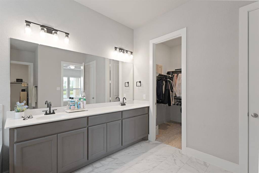 A dual-sink vanity with sleek black fixtures and direct access to the walk-in closet makes your morning routine both stylish and efficient.