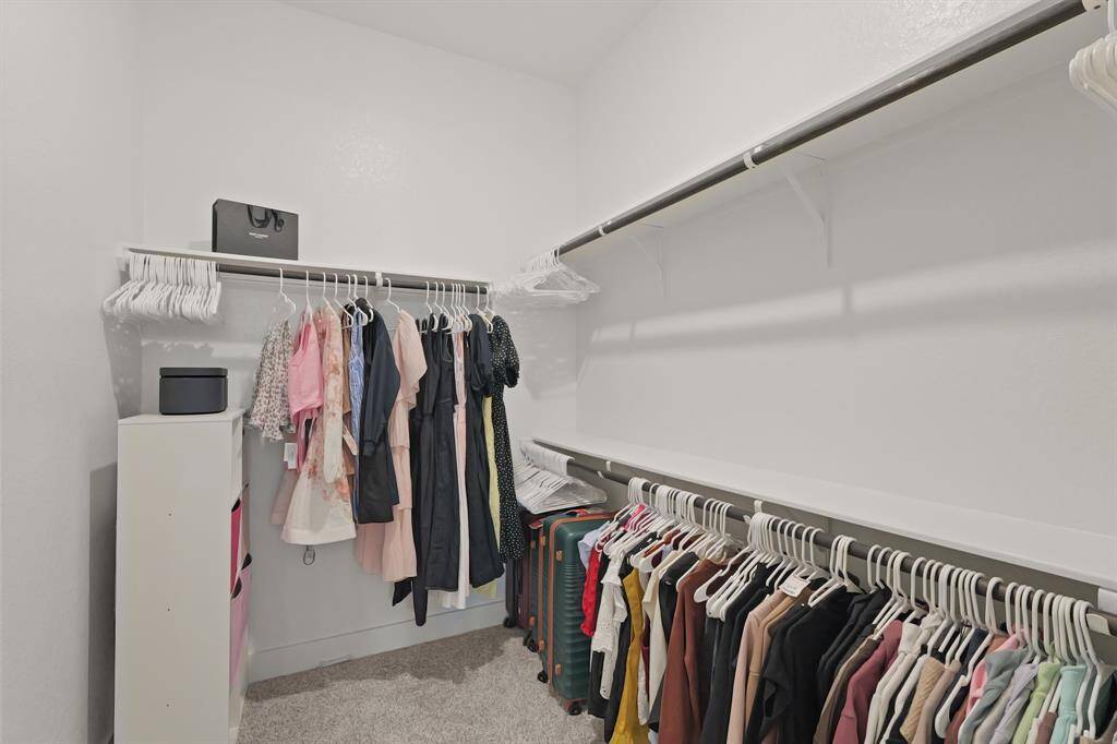 A well-appointed walk-in closet offering ample hanging space, luggage storage, and versatile shelving to fit your wardrobe needs.