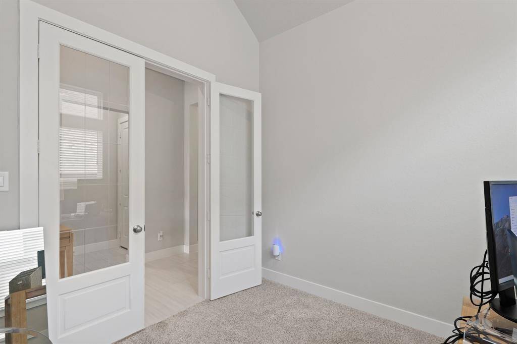 Elegant French doors provide privacy while allowing light to flow through, making this versatile room perfect for a home office, study, or reading retreat.