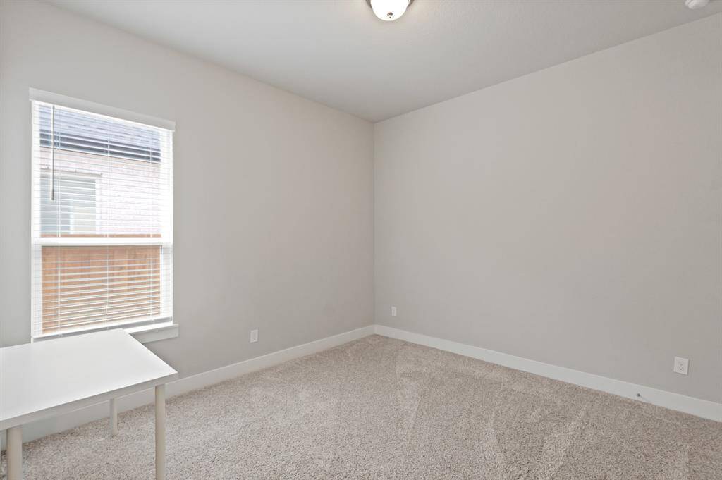 A bright and neutral bedroom featuring soft carpet and a large window that brings in natural light—ready to be tailored to your lifestyle.