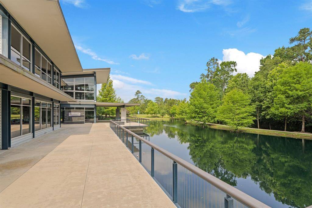 Modern clubhouse overlooking a tranquil lake offers stunning architecture and serene views, ideal for community gatherings or quiet reflection.