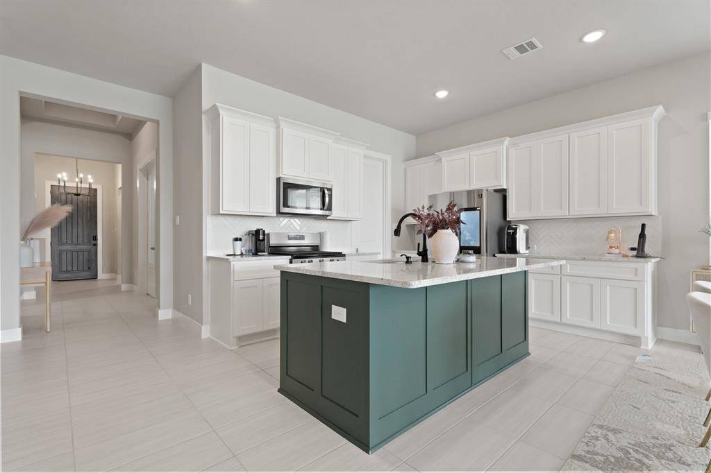 A designer kitchen layout with abundant storage, beautiful countertops, and a stylish mix of modern finishes—perfectly positioned just off the main entry for a welcoming flow.