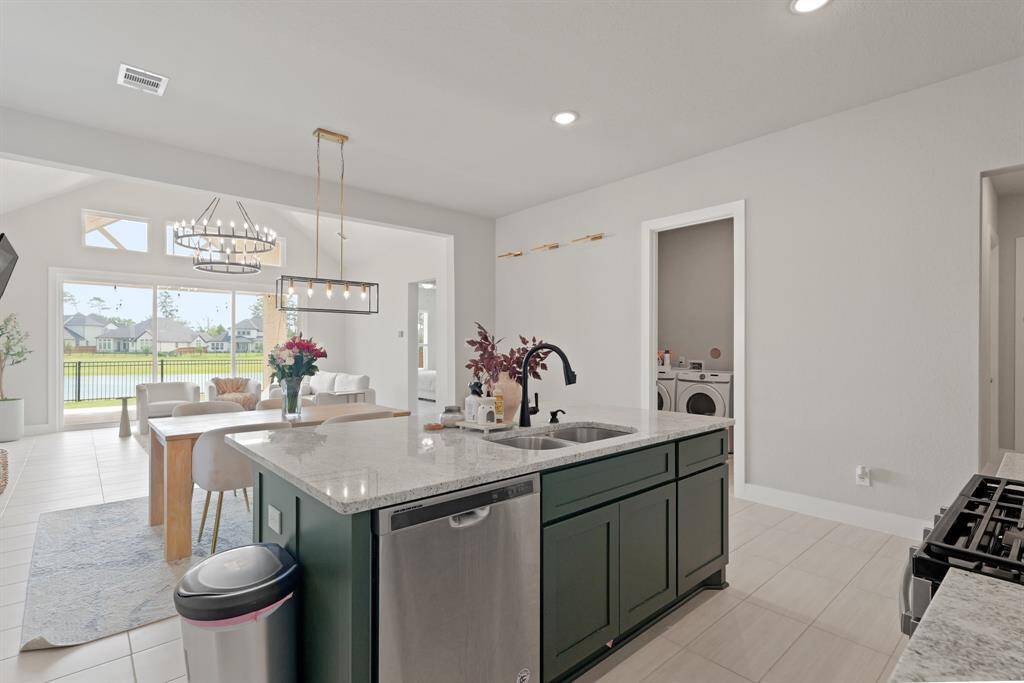 Enjoy effortless entertaining with a spacious island at the heart of the home, offering views into the elegant dining space and easy access to the laundry room for added convenience.