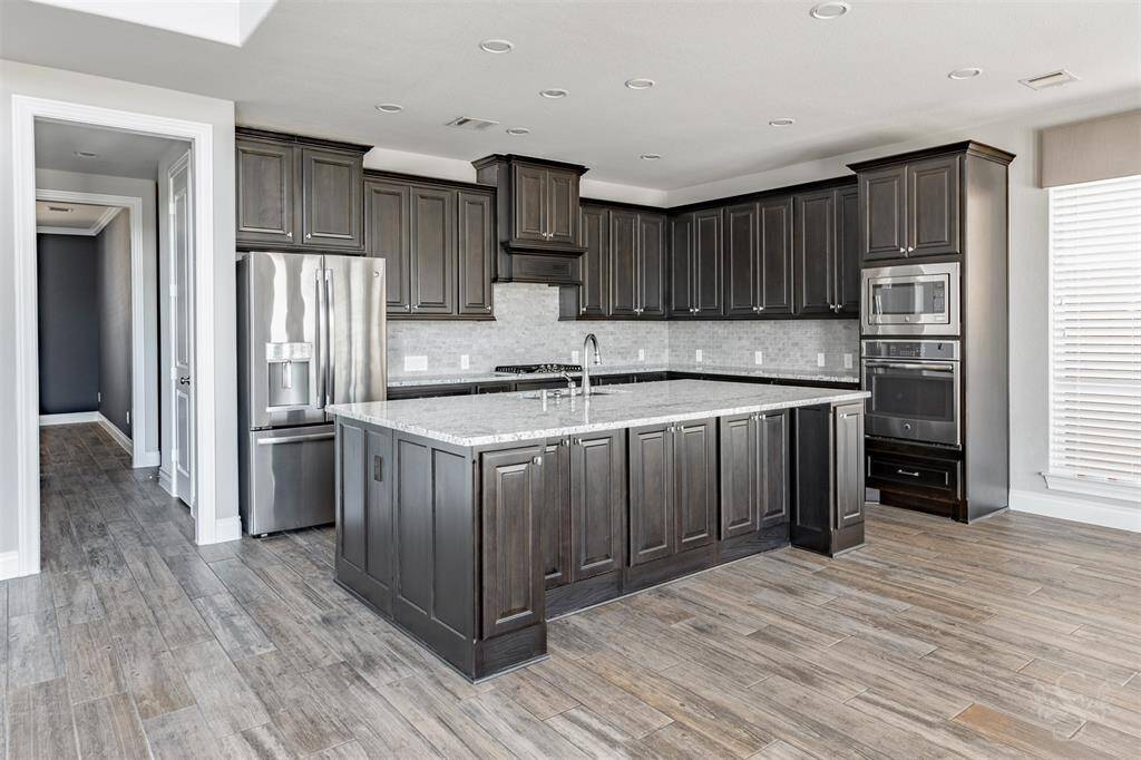 This sophisticated chef’s kitchen is the heart of the home, showcasing an expansive granite island, custom cabinetry, and stainless steel appliances. With its seamless layout and elevated finishes, it’s designed to impress and built for both grand entertaining and everyday luxury.