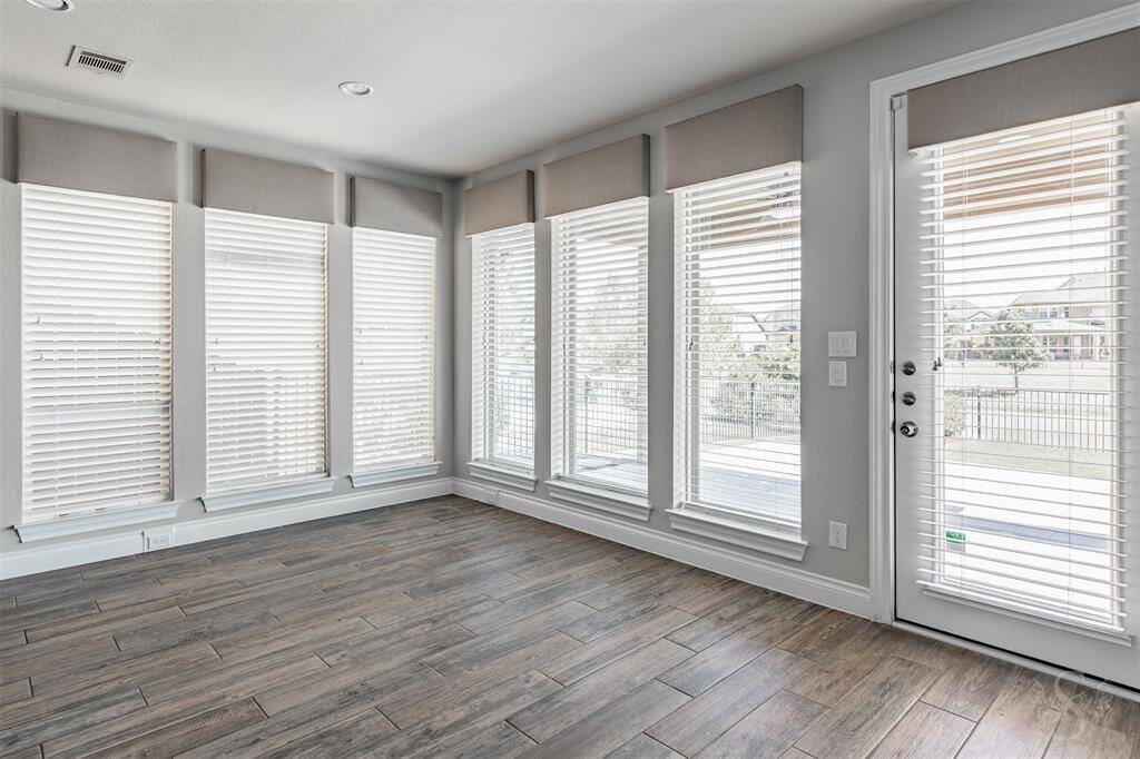 The breakfast room is drenched in natural light from a wall of picture windows, offering unobstructed views of the serene lake and manicured yard beyond. A refined yet relaxed space, it's perfect for morning coffee or intimate meals with a view.