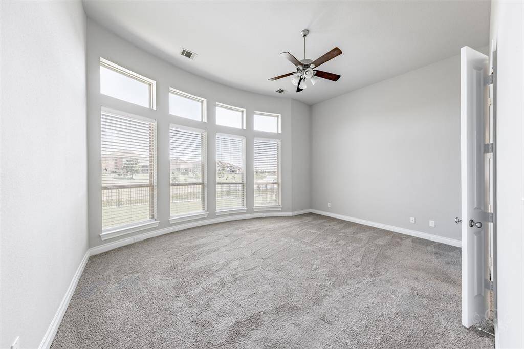 The spacious primary suite boasts a curved wall of windows with sweeping views of the lake, filling the room with natural light. With its soothing color scheme and generous proportions, this space offers a serene escape for rest and renewal.