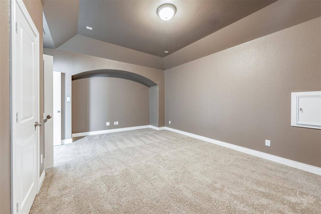 Elevate your at-home experience in this dedicated media room with custom paint, sculpted ceilings, and arched architectural niche. Designed for immersive viewing, this room is ready for your luxury home theater setup.