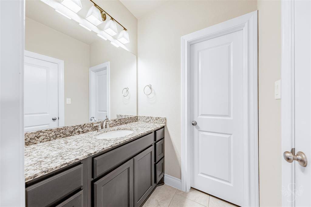 A spacious bathroom with granite vanity and stylish cabinetry, perfectly positioned to serve two upstairs bedrooms with ease.