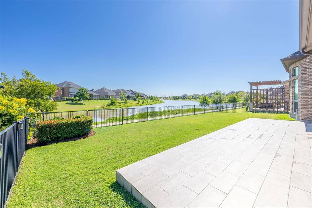 Enjoy sweeping lake views from the expansive tile patio - perfect for elegant gatherings or morning coffee. The wrought iron fence offers unobstructed views while maintaining a sense of privacy and peace.