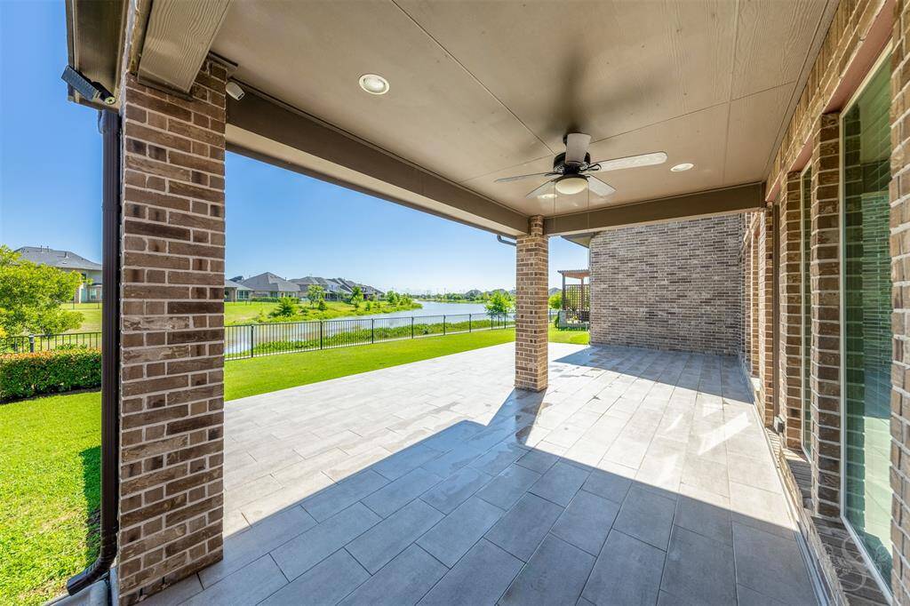 The covered patio offers cooling shade with a ceiling fan and recessed lighting, making it the ideal spot to unwind. Whether you're hosting a sunset dinner or enjoying a quiet morning, the lakefront view sets the perfect tone.