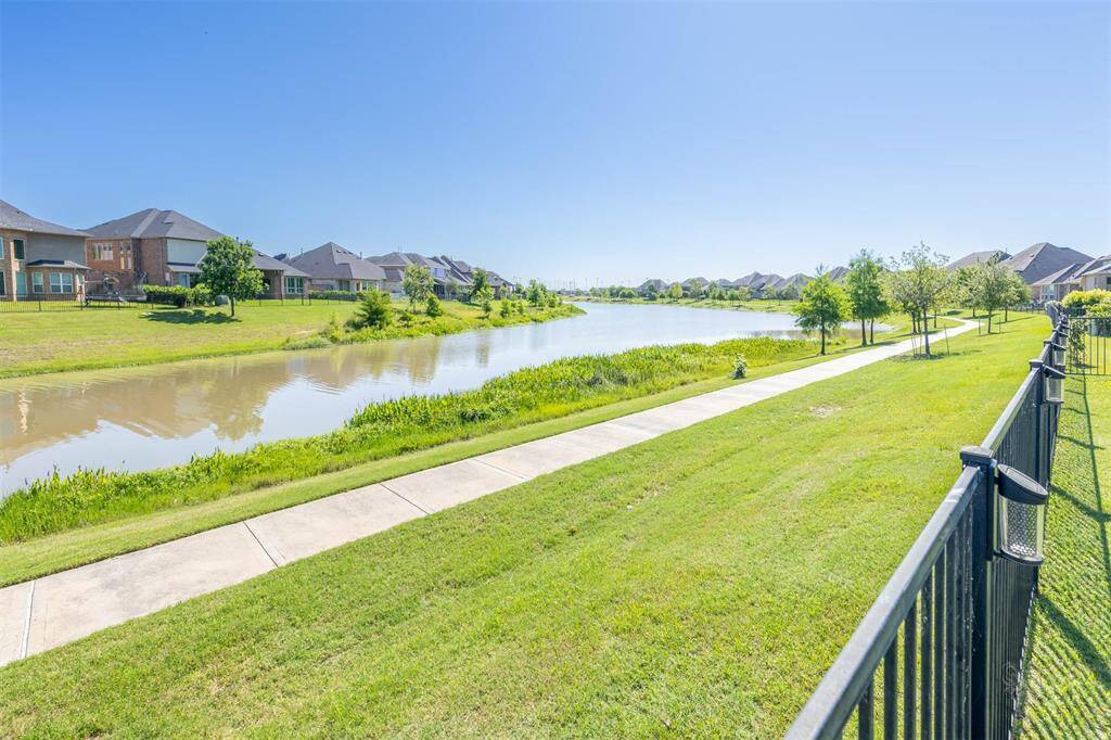 A scenic walking trail winds just beyond your backyard, offering a peaceful escape right outside your door. The gently curving shoreline adds a graceful touch to the serene setting.