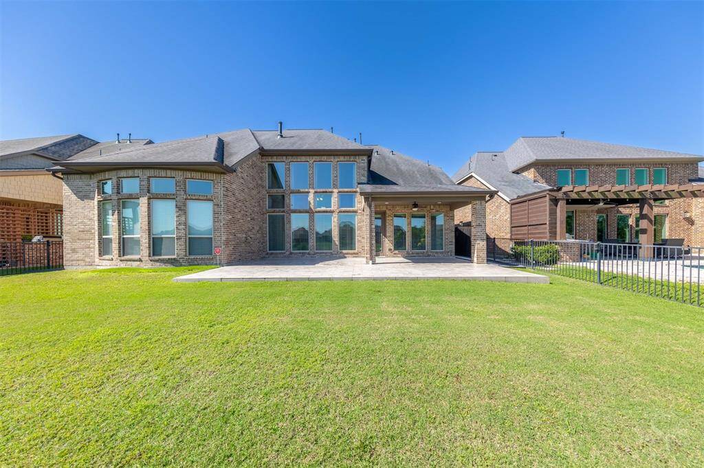 This back yard offers a stunning backdrop of calm waters and endless sky, framed by a thoughtfully designed tile patio. A seamless extension of the home’s living space, it's ready for stylish outdoor living.