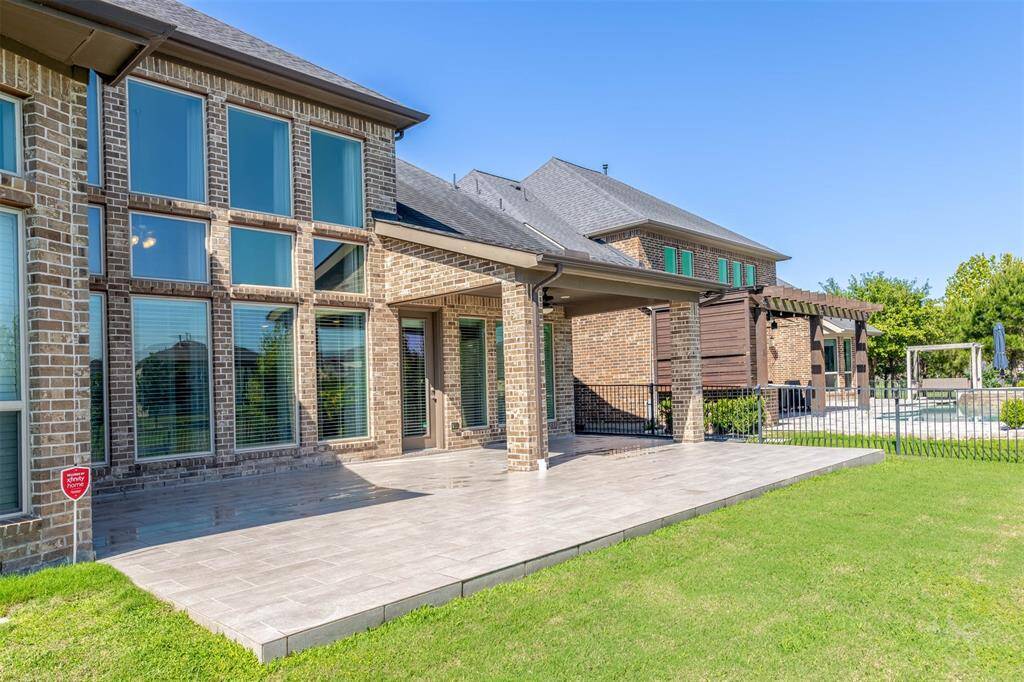Soaring windows along the rear elevation frame picturesque water views and flood the home with natural light. Expansive tiled patio provides the perfect setting for entertaining, all while enjoying uninterrupted views of the tranquil lakefront.