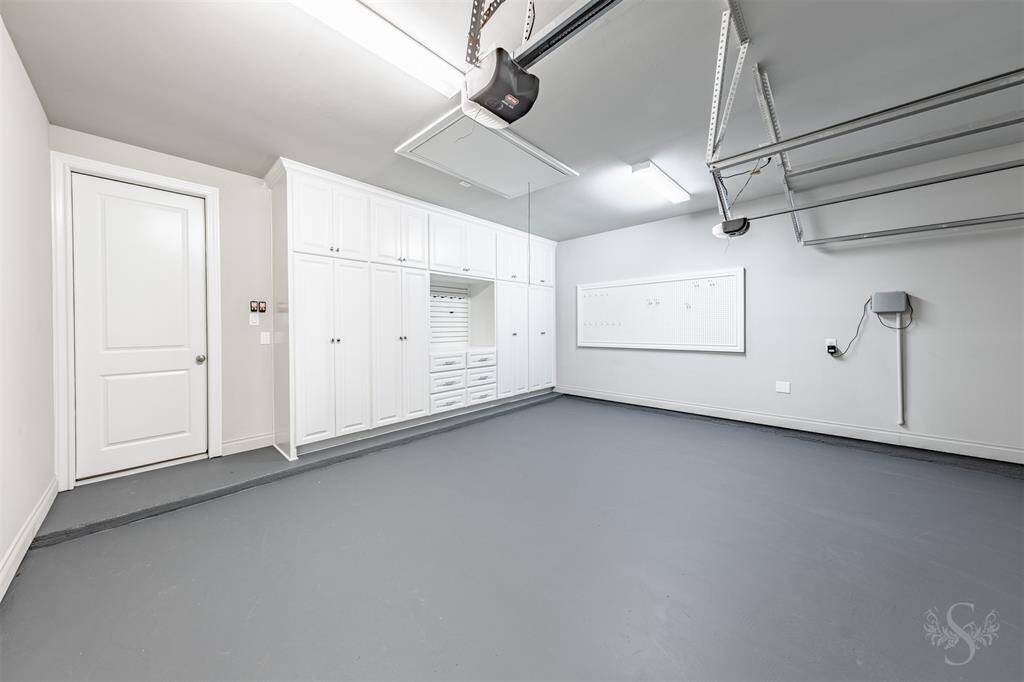 This immaculate 2 car garage includes extensive built-in cabinetry, a custom workstation, and sleek epoxy flooring. Ideal for the car enthusiast or craftsman, it combines high function with polished organization. A single car garage is separate.
