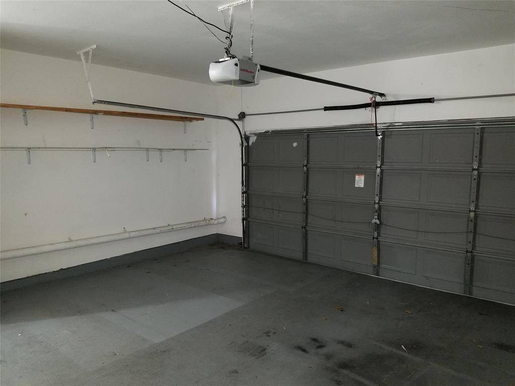 Two car garage with auto door opener, plus storage on the side.