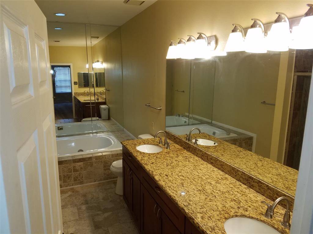 Granite counter with double sinks and spa tub. Custom tile floors.
