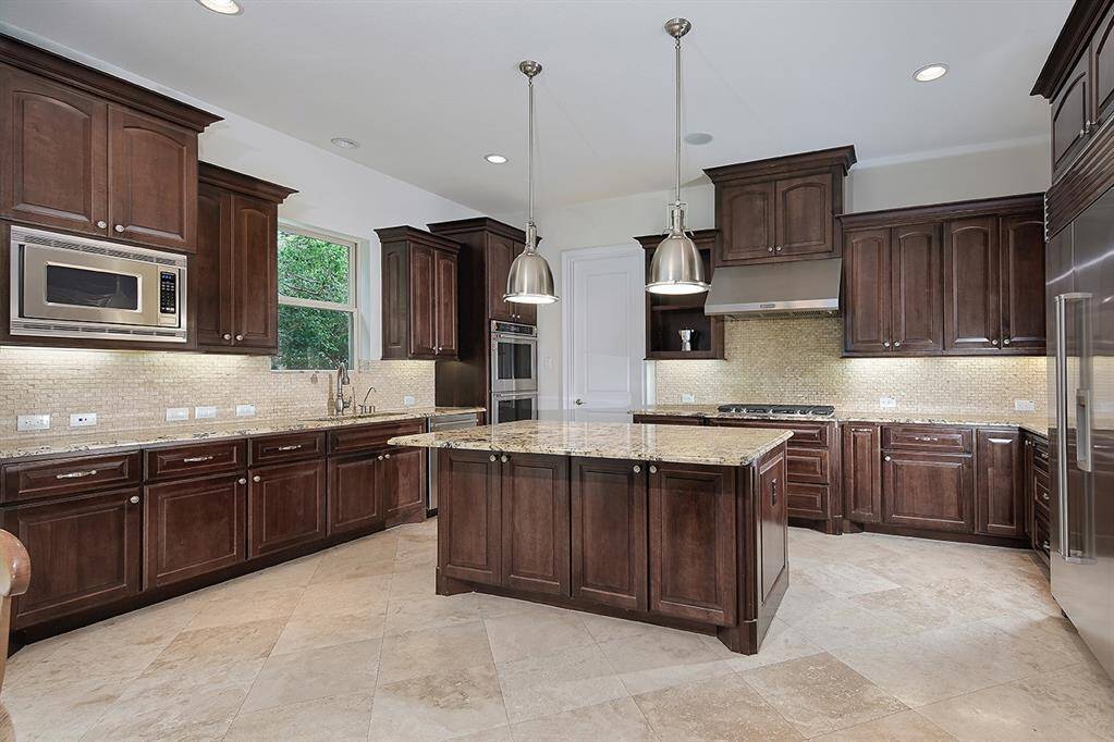 Gourmet kitchen features stunning granite counters, custom cabinetry, Bosch dishwasher, upgraded dual ovens and new gas cooktop
