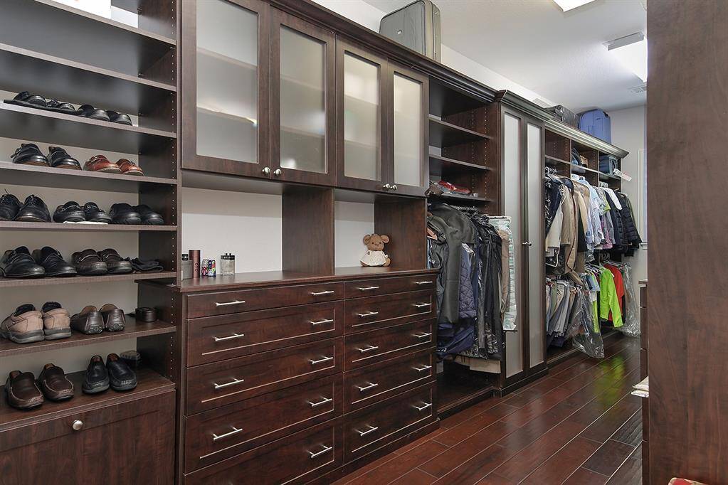 Amazing primary closet with custom storage and shelving