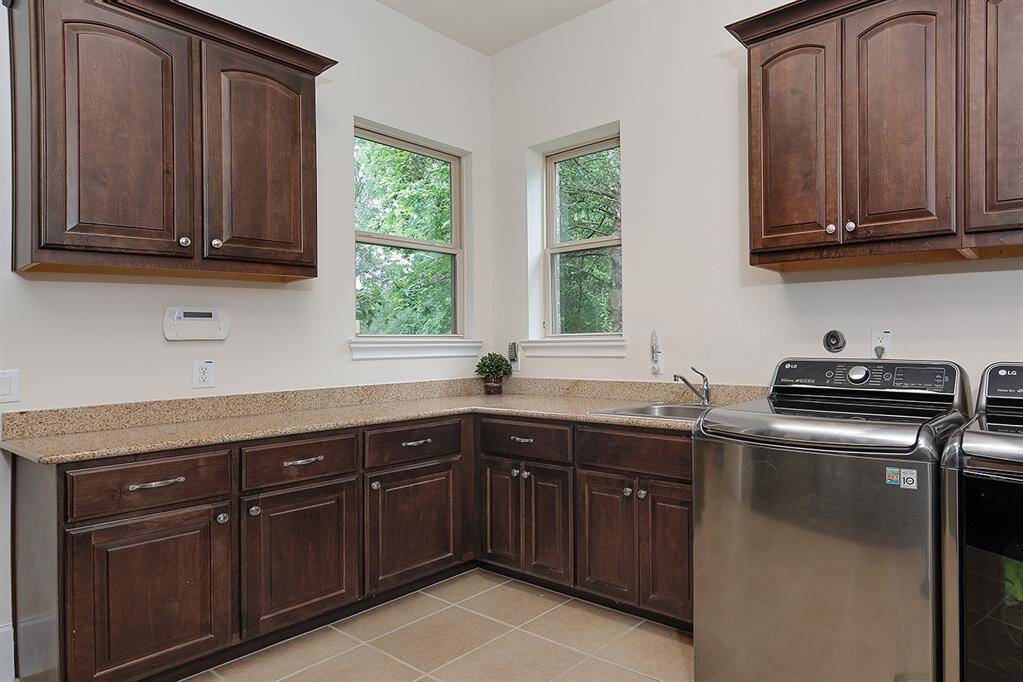 Sizeable laundry with custom built-in storage solutions