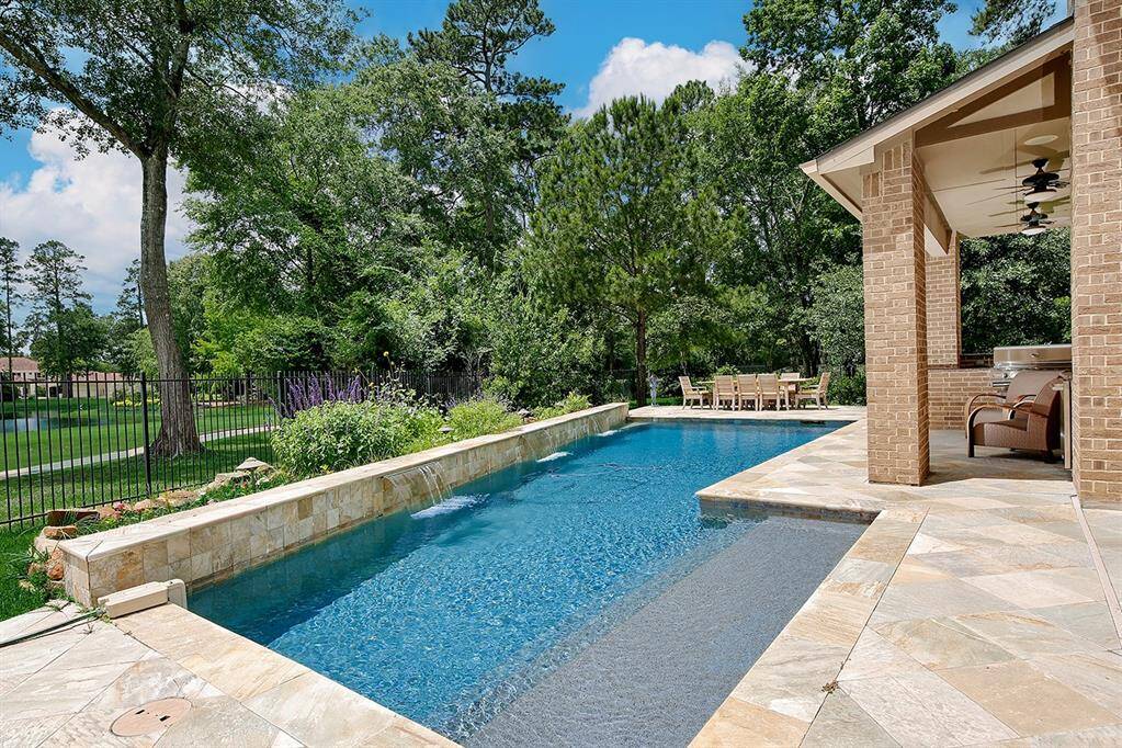Sparkling pool with low profile, cascading waterfalls to enjoy the best views the Woodlands has to offer
