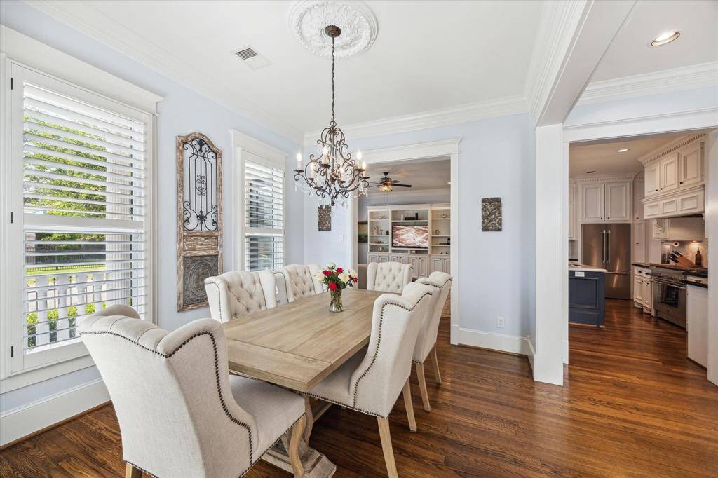 Bright and elegant dining room featuring windows on two sides, filling the space with natural light.