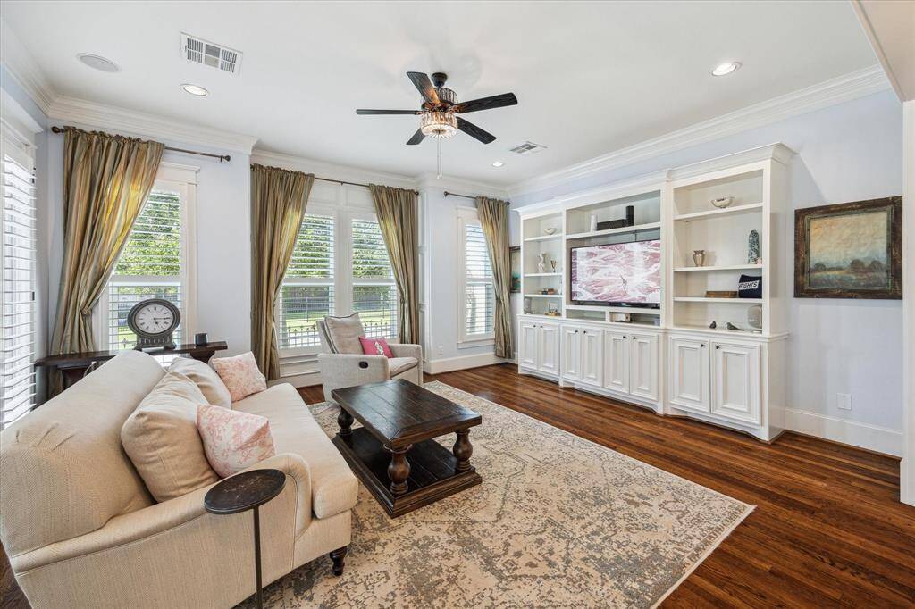 Additional kitchen features include a luxurious marble island with a breakfast bar, beautifully accented by two chandelier pendants. The space also boasts an appliance garage for clutter-free countertops, under cabinet lighting and a roomy walk-in pantry for seamless organization.