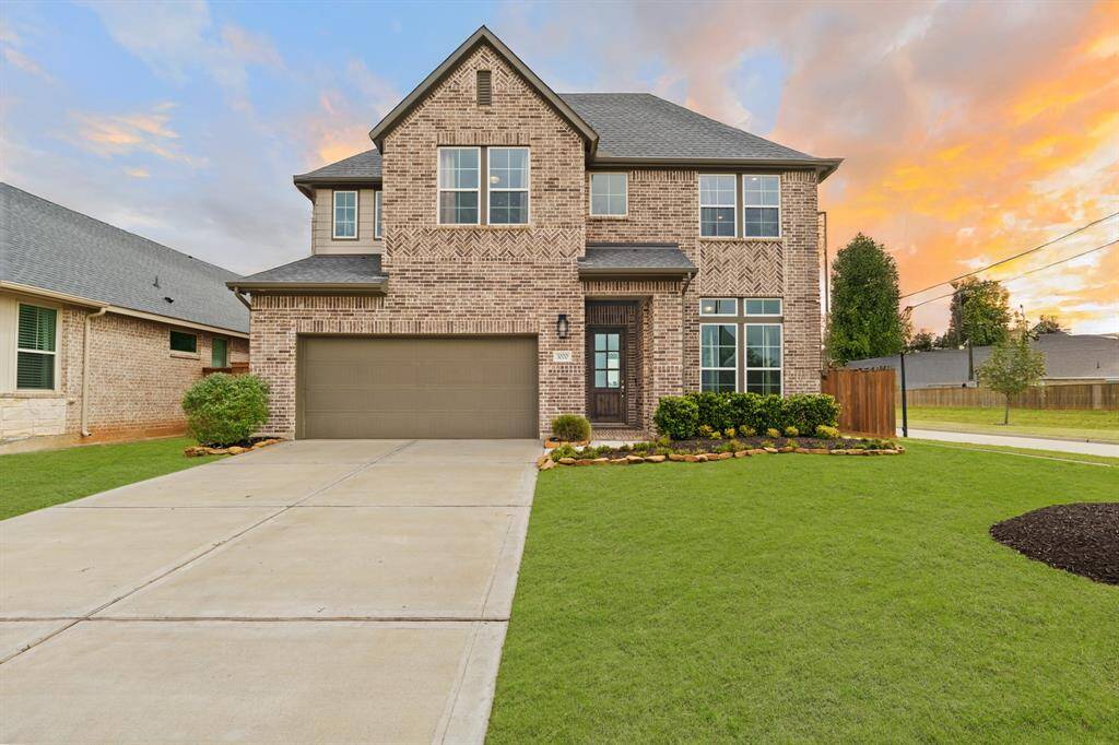 This beautifully maintained two-story brick home features a spacious driveway, charming curb appeal, and a fully landscaped front yard—set against a stunning sunset backdrop.