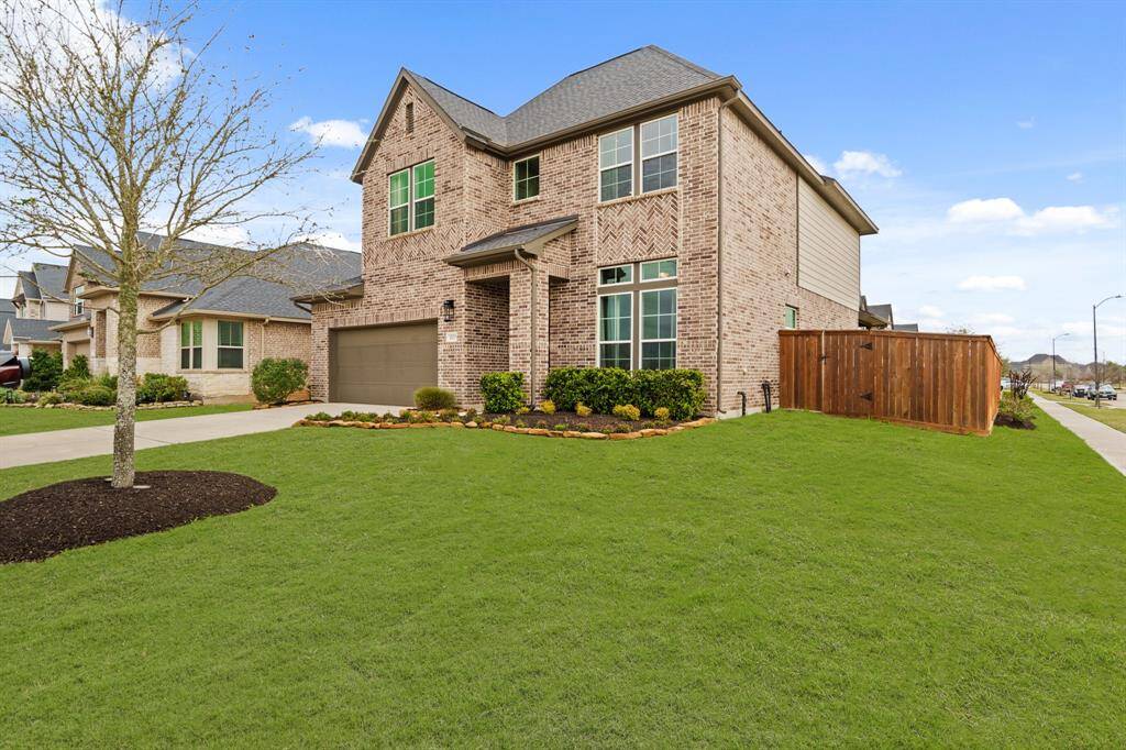 Corner lot beauty with immaculate brickwork, manicured landscaping, and a private side yard perfect for relaxing or entertaining.