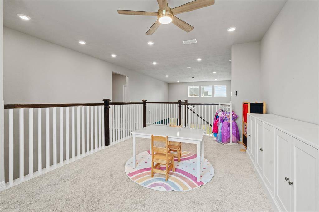 Expansive upstairs loft ideal for play, learning, or lounging with open railing and recessed lighting.