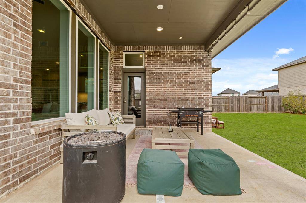 Cozy covered patio with room for seating and grilling, perfect for outdoor entertaining in any weather.